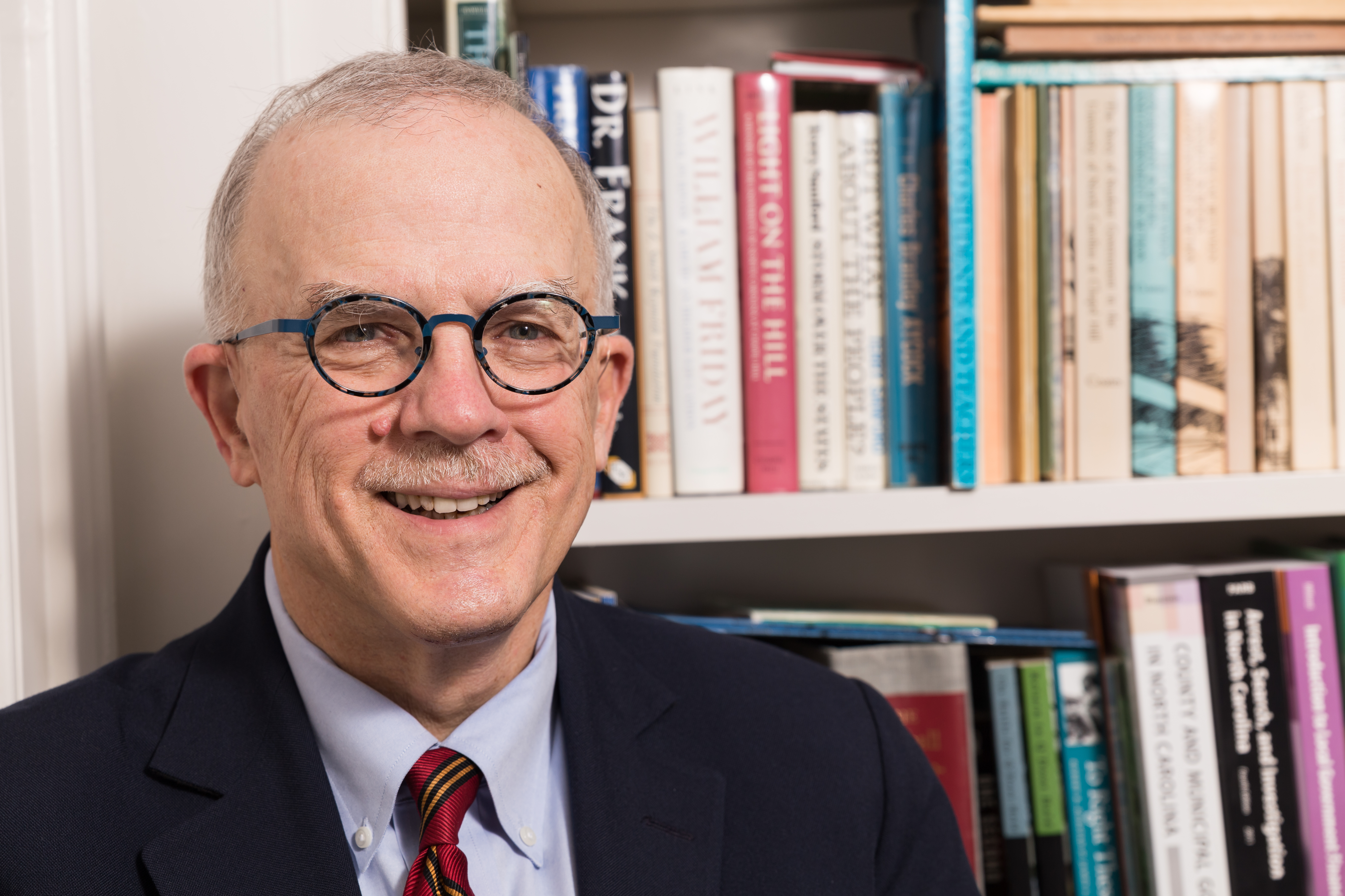 Mike Smith in front of shelves of books