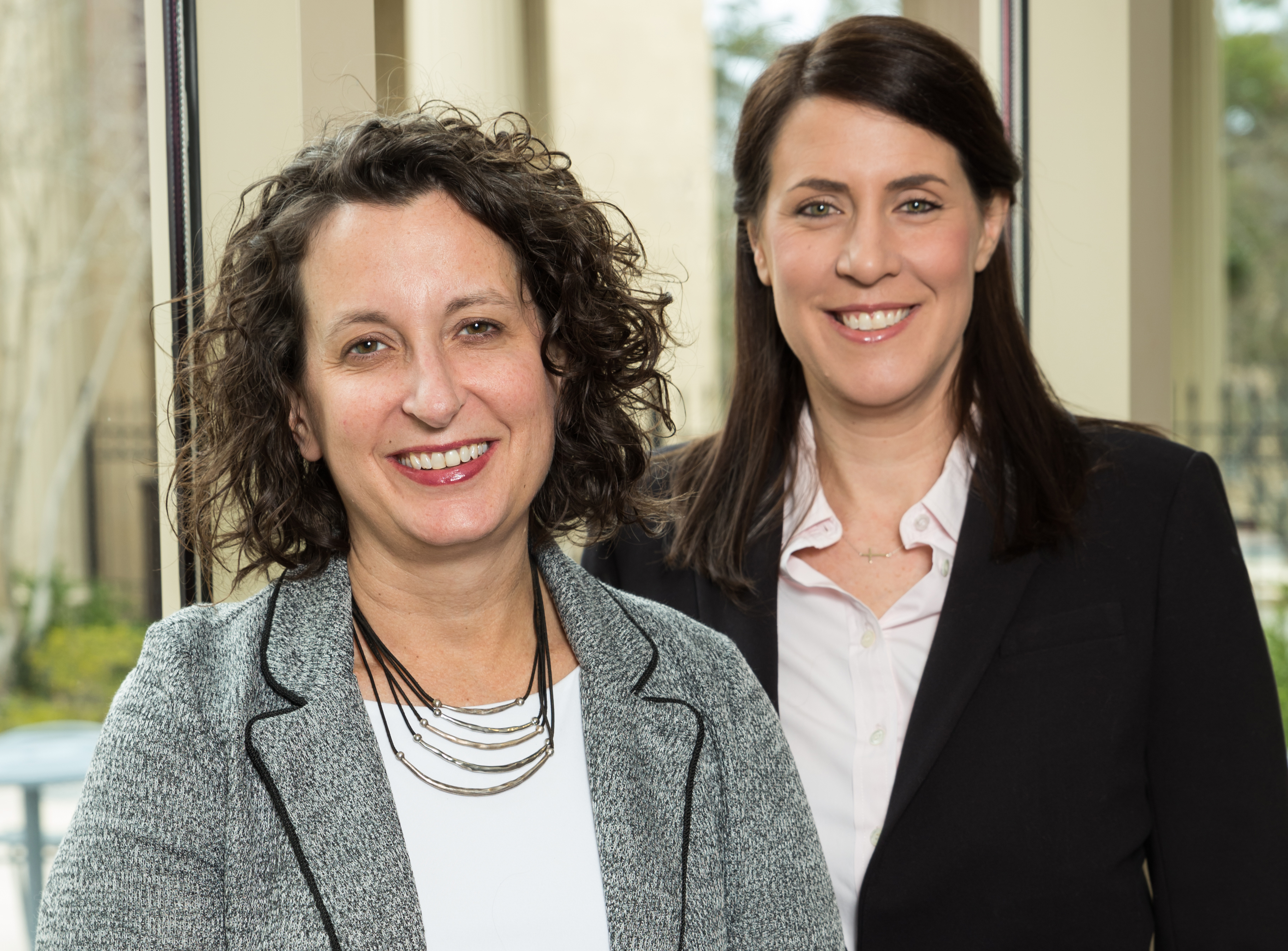 Aimee Wall stands to the left of Meredith Smith at the School of Government