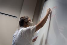 A fellow in the LFNC program writes on a white board at the summer training academy.
